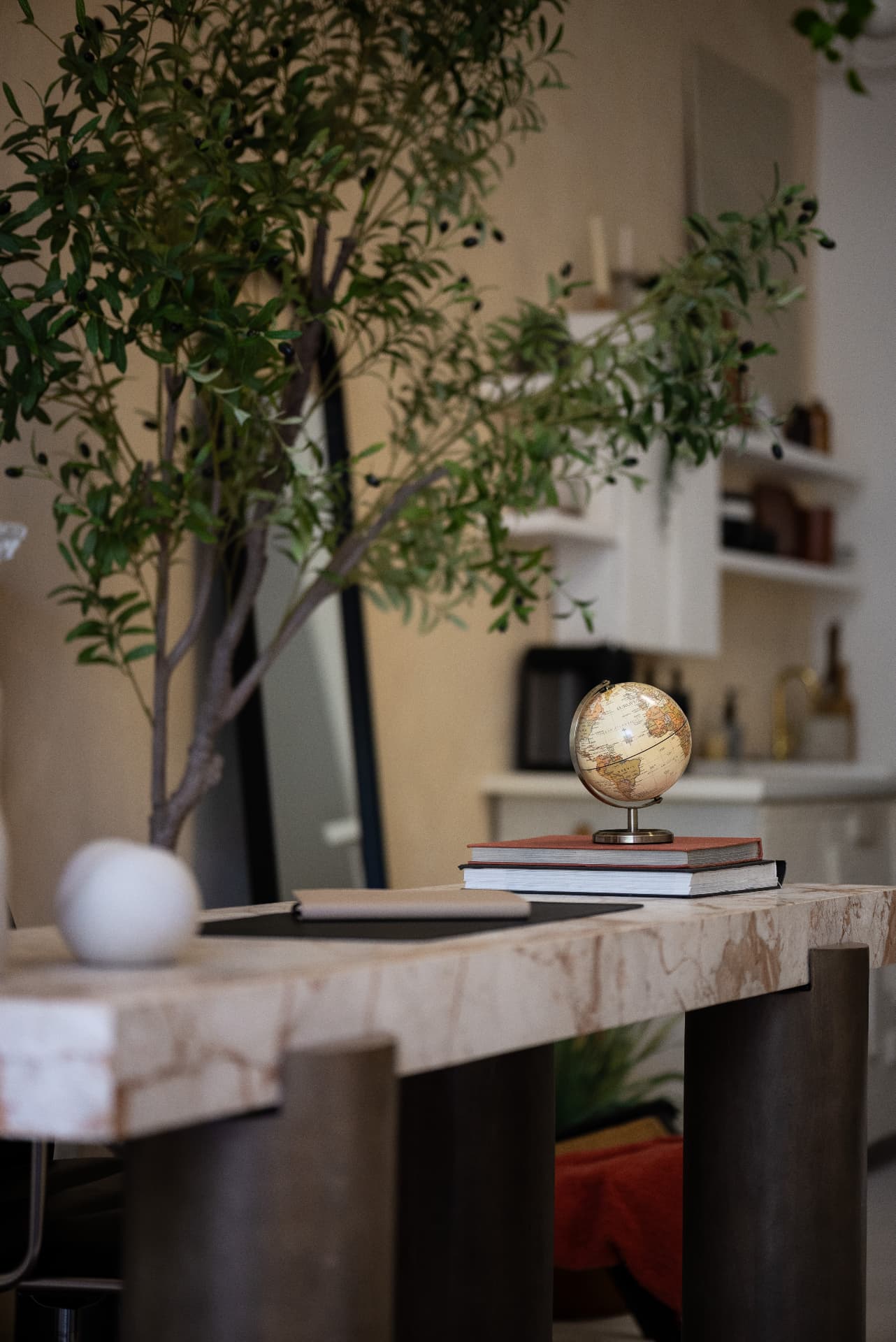 French learning books, a laptop and a globe in a warm study space.